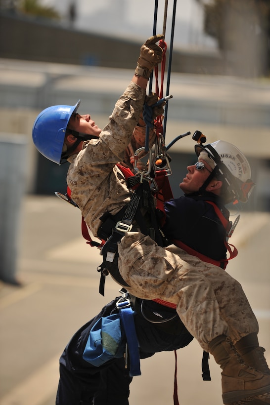 Cpl. Dustin L. Lamb, left, rappels from the side of a building to rescue a mock stranded individual during training aboard the San Francisco Firefighter School here July 13. Lamb, a Grand Junction, Colo., native and a vertical construction engineer with the 11th Marine Expeditionary Unit's combat logistics element is preparing for an upcoming deployment later this year.